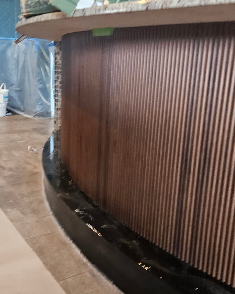 Warm curved wood-slat detailing going in
