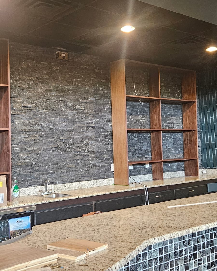 A backlit wood-slat feature wall taking shape inside